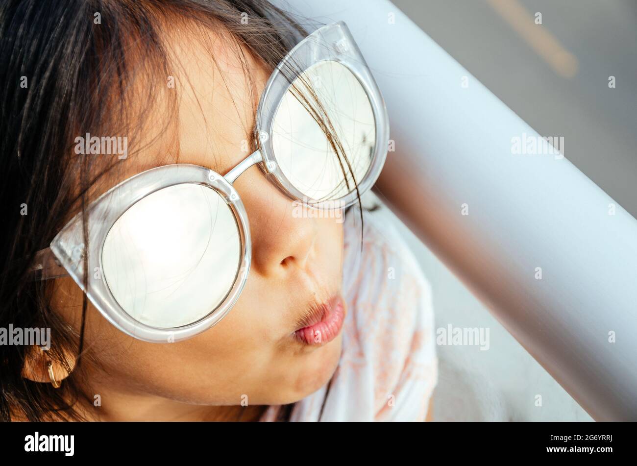 Happy little girl with big sunglasses looking at the sun. Stock Photo