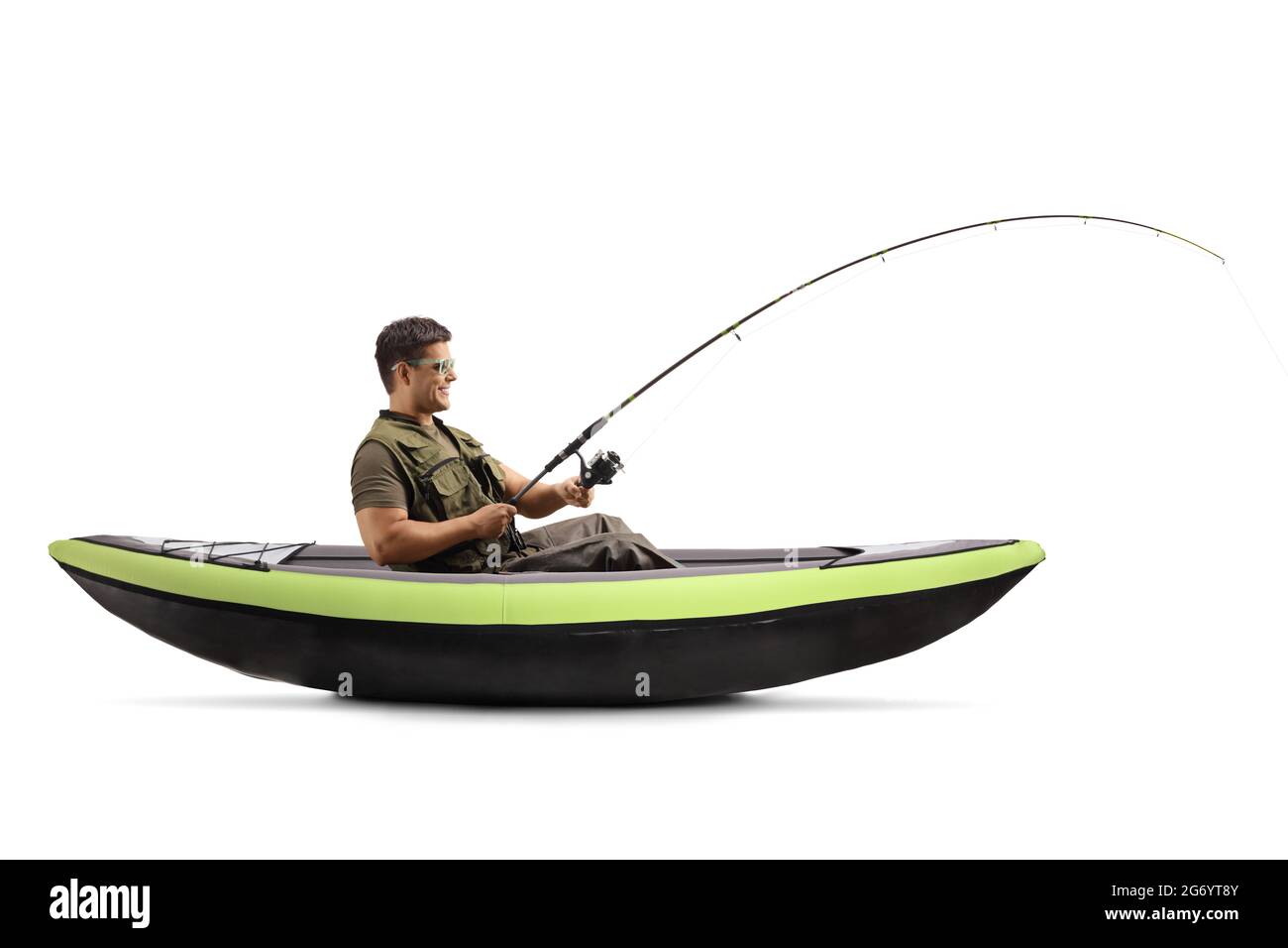 Side shot of a young man catching fish from a canoe isolated on white