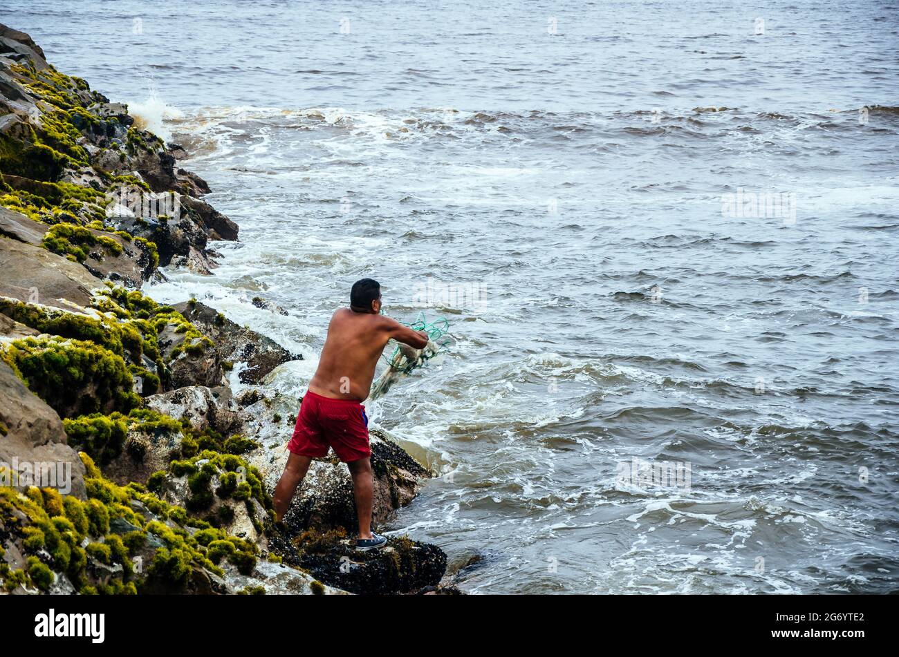 Fisherman pulling fishing net on the beaches of Lima, Peru. Stock Photo