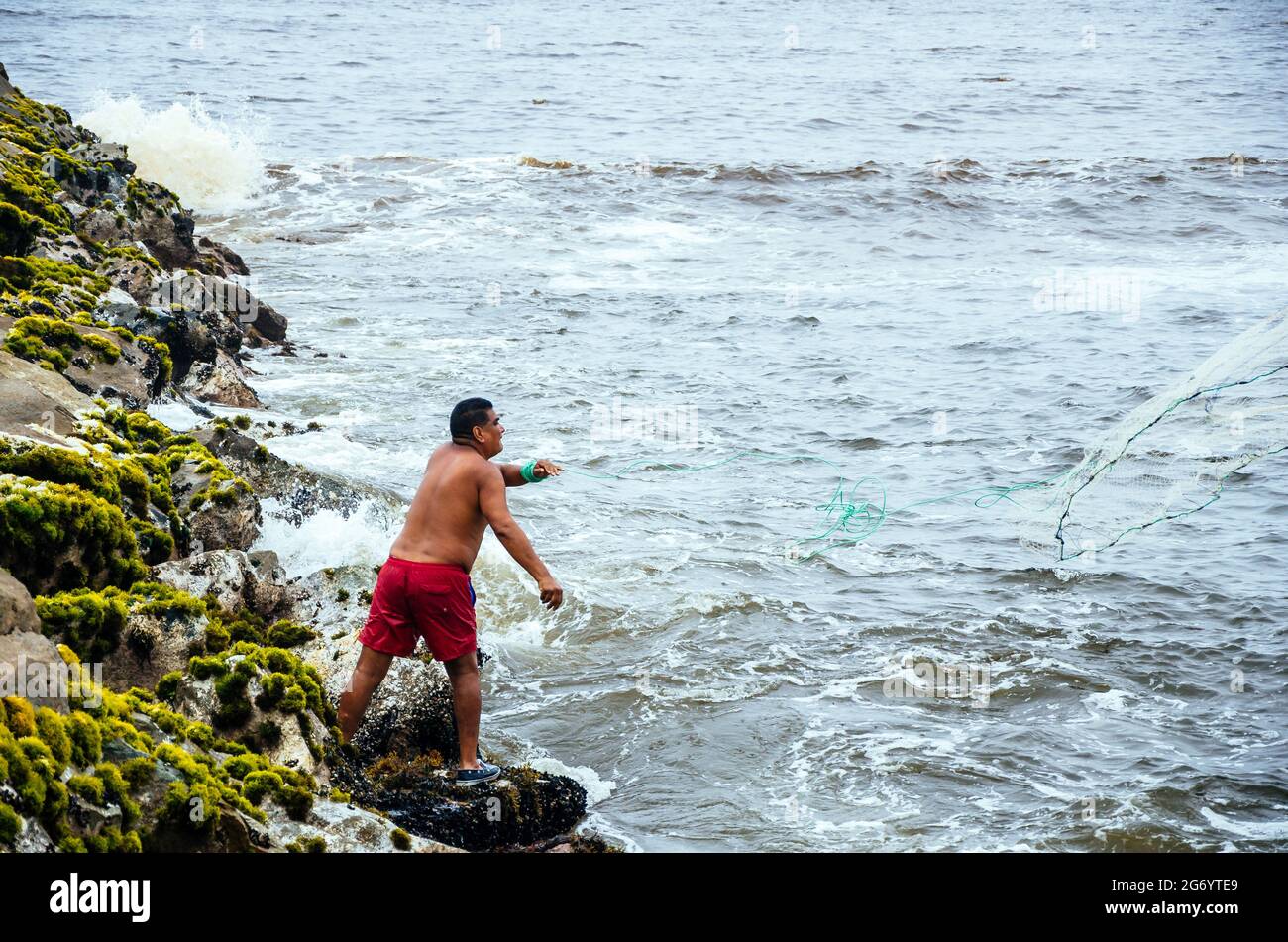 Fisherman pulling fishing net on the beaches of Lima, Peru. Stock Photo