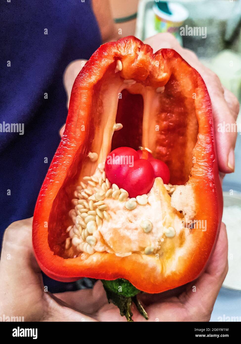 Red paprika with seeds and small baby pepper inside Stock Photo - Alamy