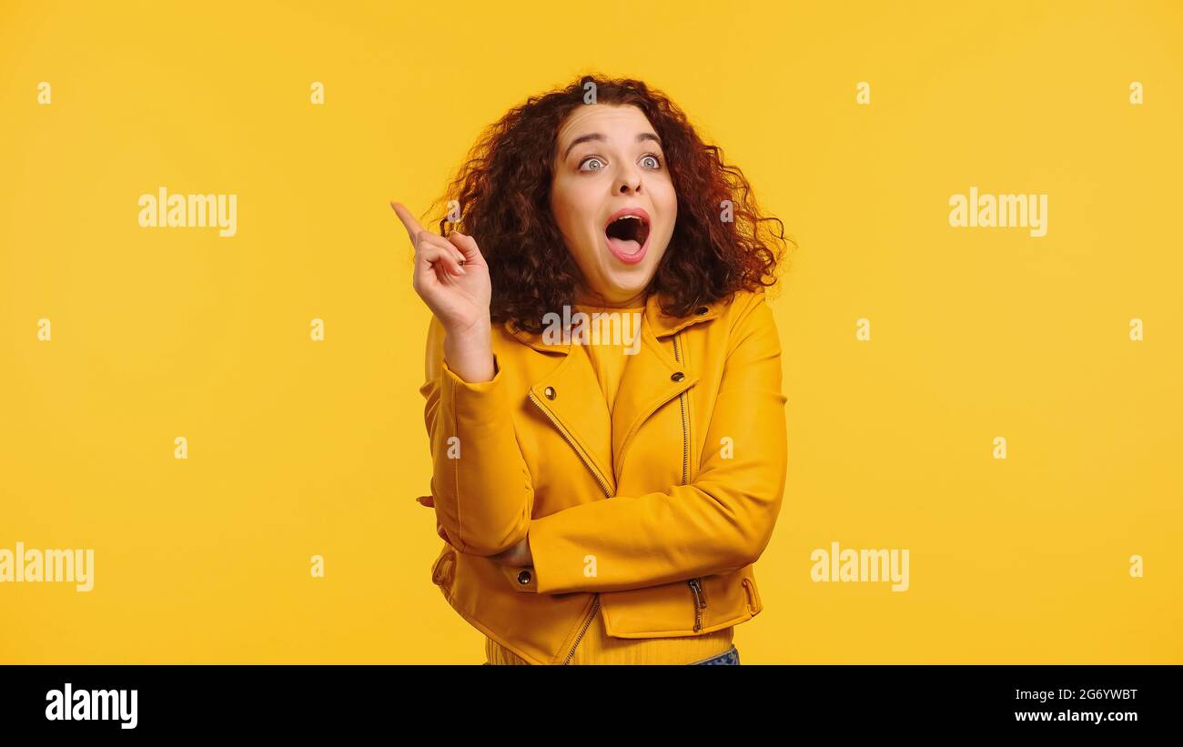 amazed young woman having idea isolated on yellow Stock Photo
