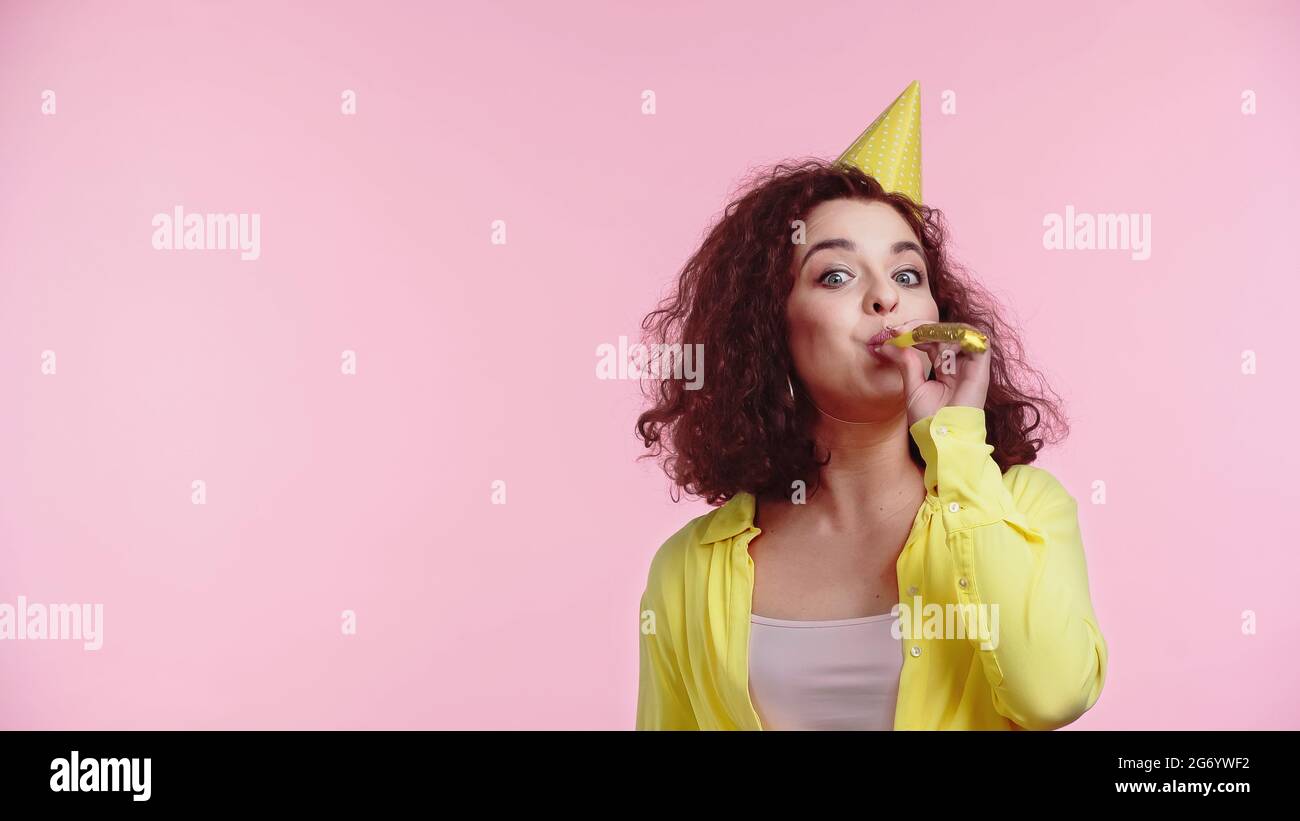 Young woman blowing party horn hi-res stock photography and images - Alamy