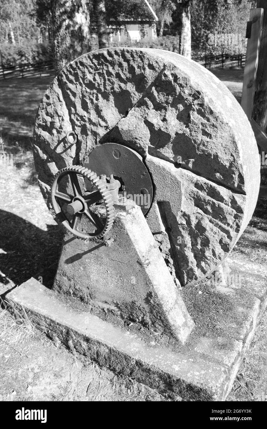 Vertical grayscale shot of a grindstone outdoors under sunlight Stock Photo