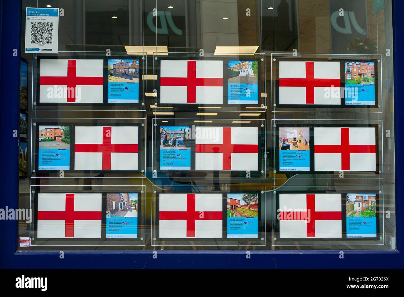 Uxbridge, London Borough of Hillingdon, UK. 9th July, 2021. England flags in an Estate Agents window ahead of the UEFA Euro 2020 final between England and Italy this Sunday. Credit: Maureen McLean/Alamy Live News Stock Photo