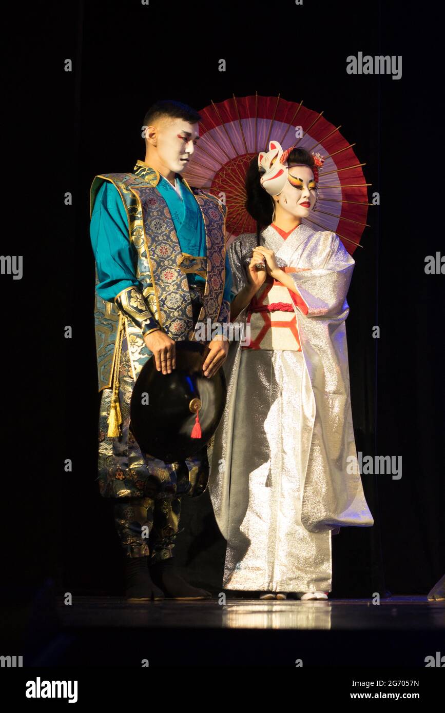 Japanese couple in traditional costumes standing on a dark background. Stock Photo