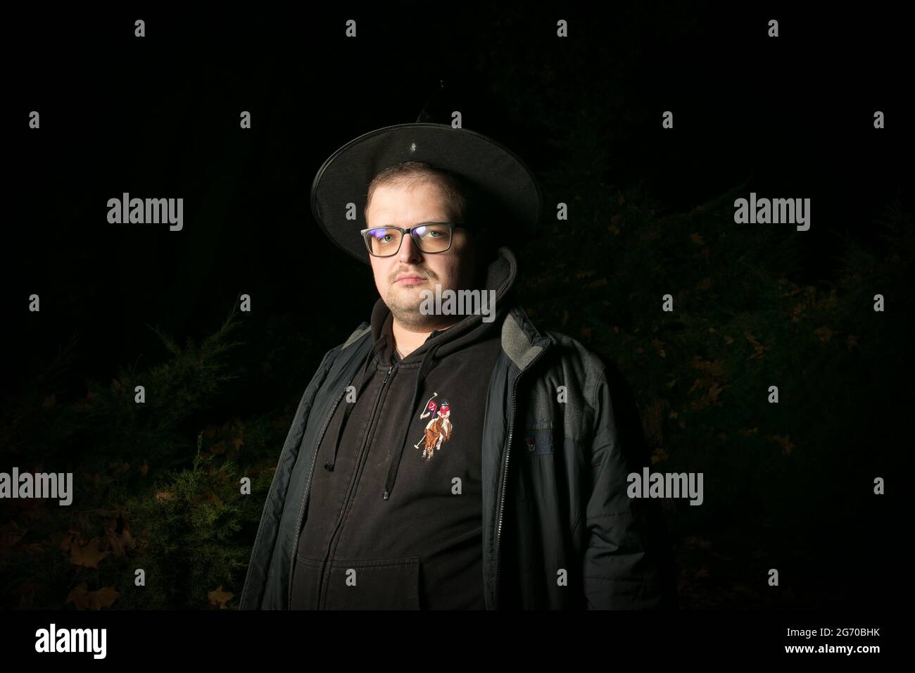 Portrait of a man with glasses in a wizard's cap. Halloween is coming. Stock Photo