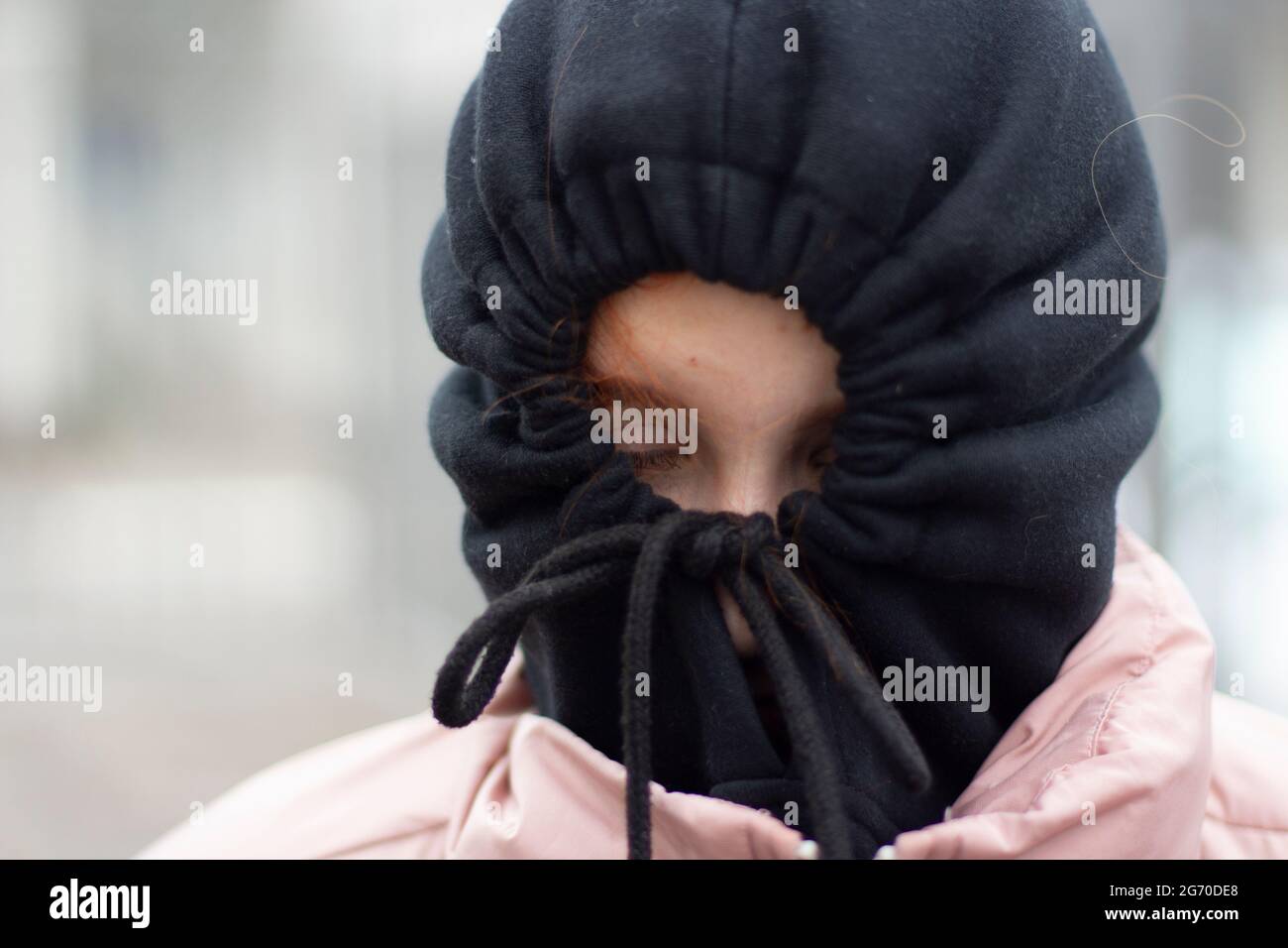 The girl hid in the hood. Girl in a black hood. The schoolgirl hid from people. Self-rejection. The man is depressed. Reluctance to communicate. Stock Photo