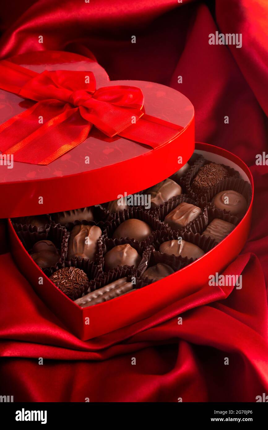 A Box of Milk Chocolates in a Red Love Heart on a Bed with Red Silk Sheets  Stock Photo - Alamy