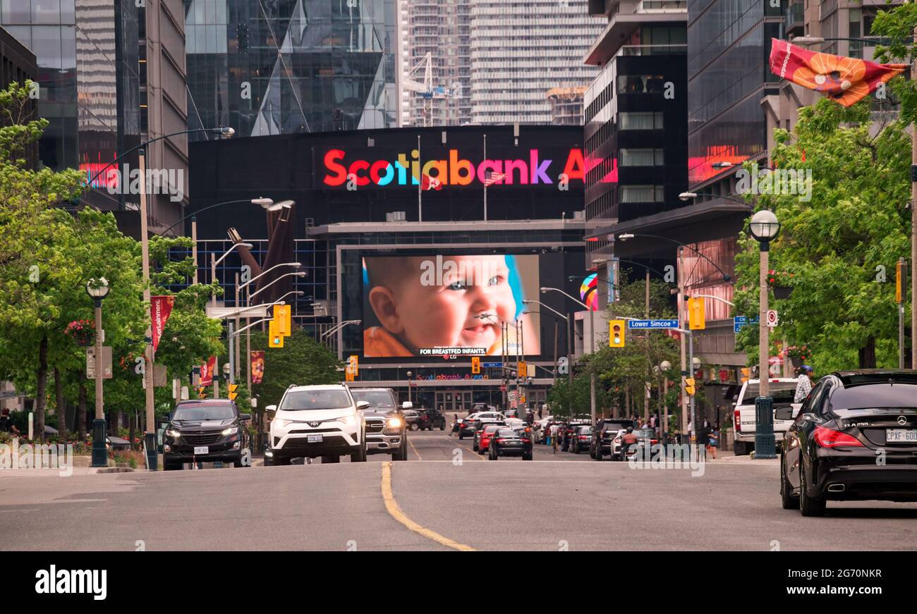 TORONTO, CANADA - 06 05 2021: Summer view along Bremner Blvd with cars in foreground and Scotiabank Arena building with enormous ad screen showing Stock Photo