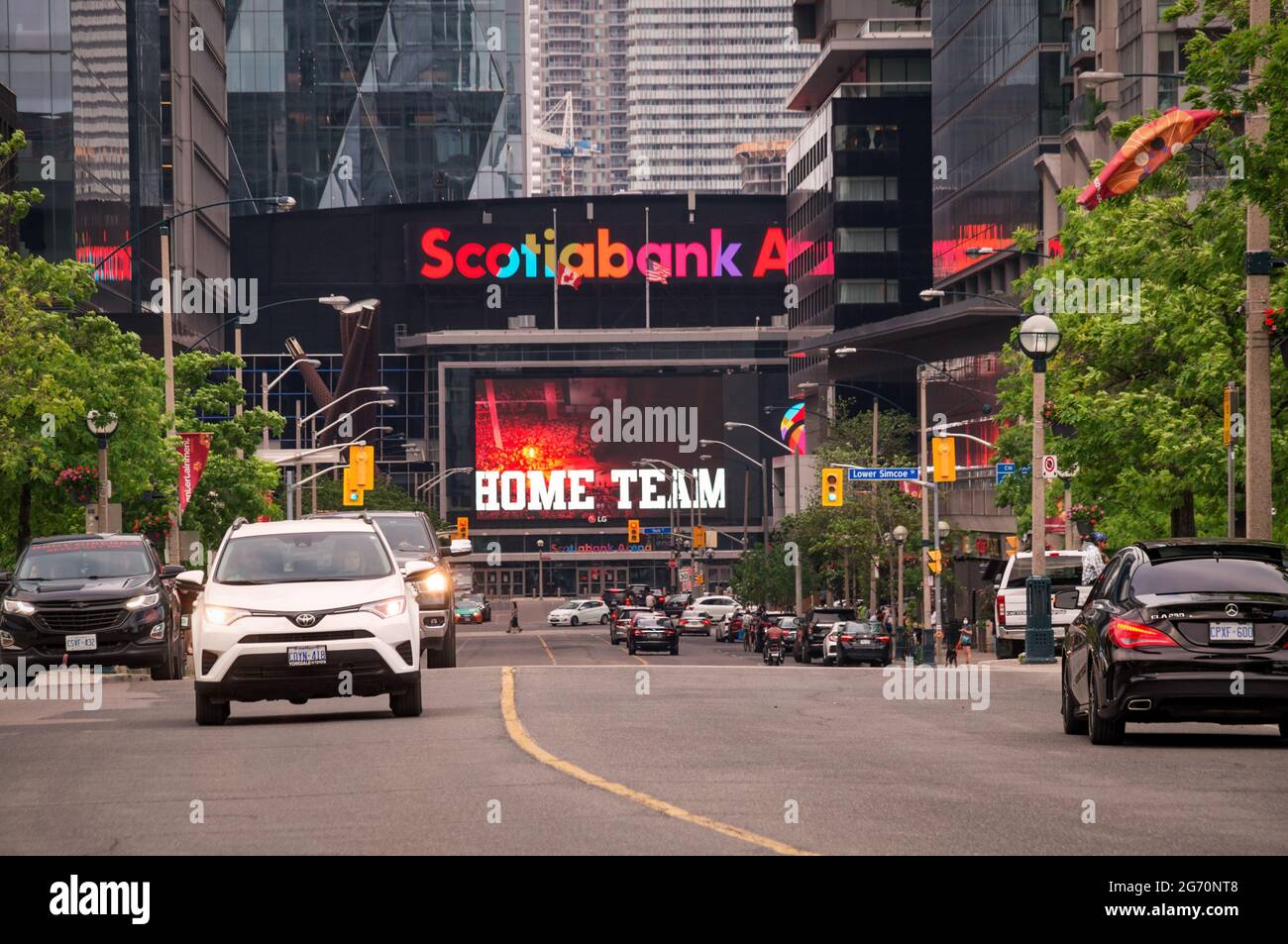 TORONTO, CANADA - 06 05 2021: Summer view along Bremner Blvd in downtown Toronto with cars in foreground and Scotiabank Arena building with enormous Stock Photo
