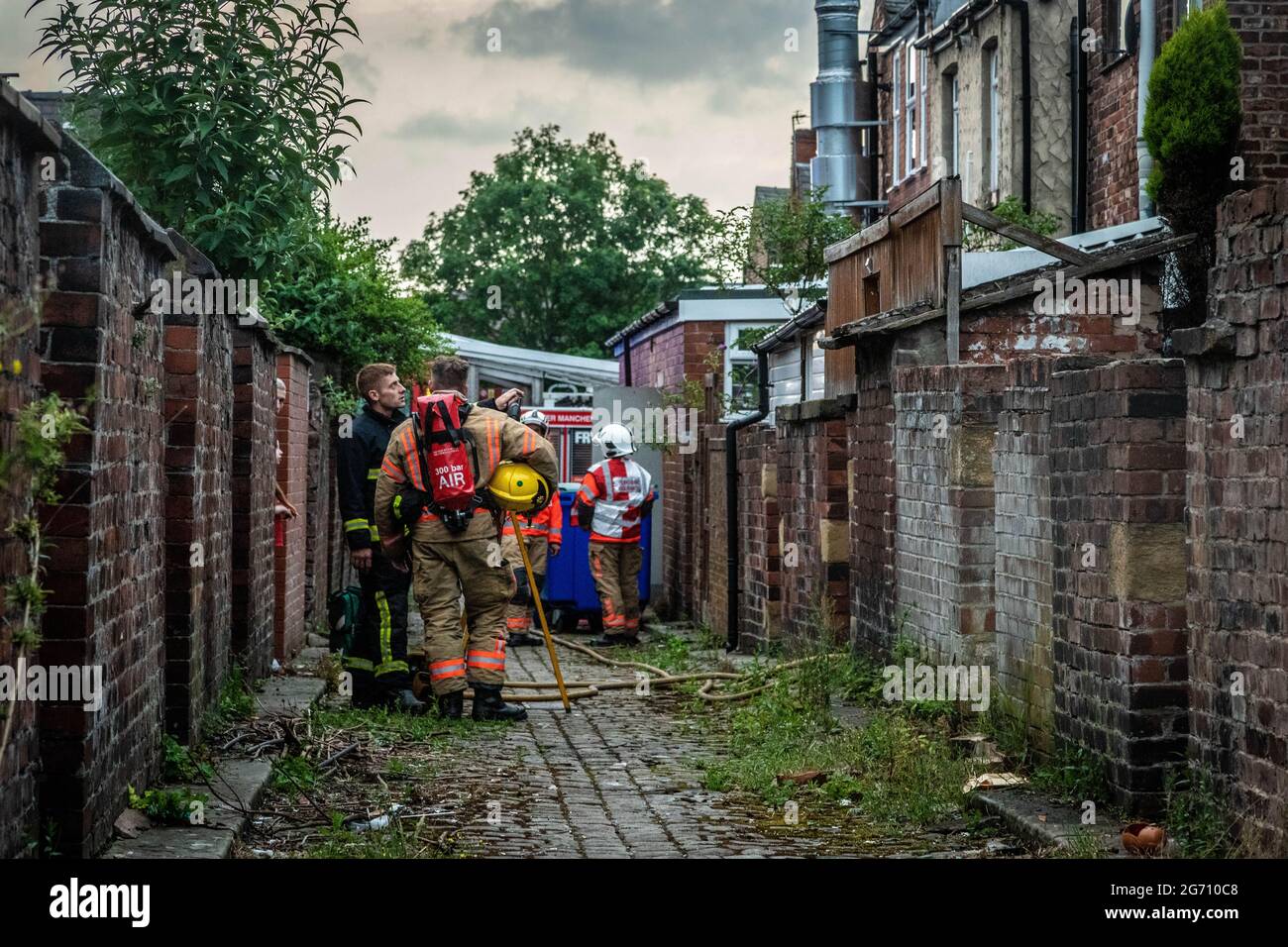 Manchester, UK. 09th July, 2021. Fire fighters seen in an rear alley to stop the house fire in Failsworth.Greater Manchester Fire Service block off Norman Street, Failsworth after a house fire in a flat on Manchester Road. Residents say the house fire was caused by a man who wanted to commit suicide however conflicting reports also came me that the man was cooking. Two fire trucks and a fire commander responded to the scene. (Photo by Ryan Jenkinson/SOPA Images/Sipa USA) Credit: Sipa USA/Alamy Live News Stock Photo