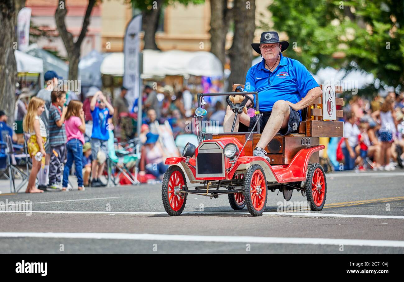 Prescott, Arizona, USA - July 3, 2021: Man driving a minature antique car replica in the 4th of July parade Stock Photo