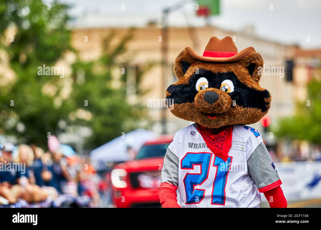 Prescott, Arizona, USA - July 3, 2021: Participant wearing a Raccoon costume while marching in the 4th of July parade Stock Photo