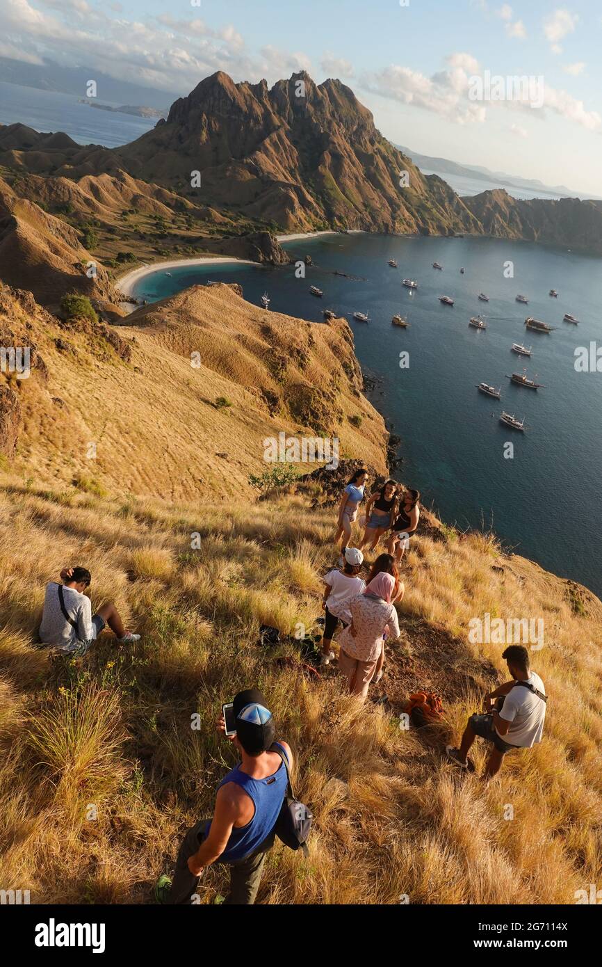 Padar, Indonesia - July 3 2021: Indonesian tourists pose for photo and takes selfies at the famous viewpoint of Padar island in the Komodo national pa Stock Photo