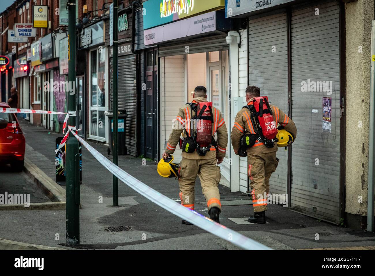 Manchester, UK. 09th July, 2021. Firefighters walk to the scene of the house fire in Manchester.Greater Manchester Fire Service block off Norman Street, Failsworth after a house fire in a flat on Manchester Road. Residents say the house fire was caused by a man who wanted to commit suicide however conflicting reports also came me that the man was cooking. Two fire trucks and a fire commander responded to the scene. Credit: SOPA Images Limited/Alamy Live News Stock Photo