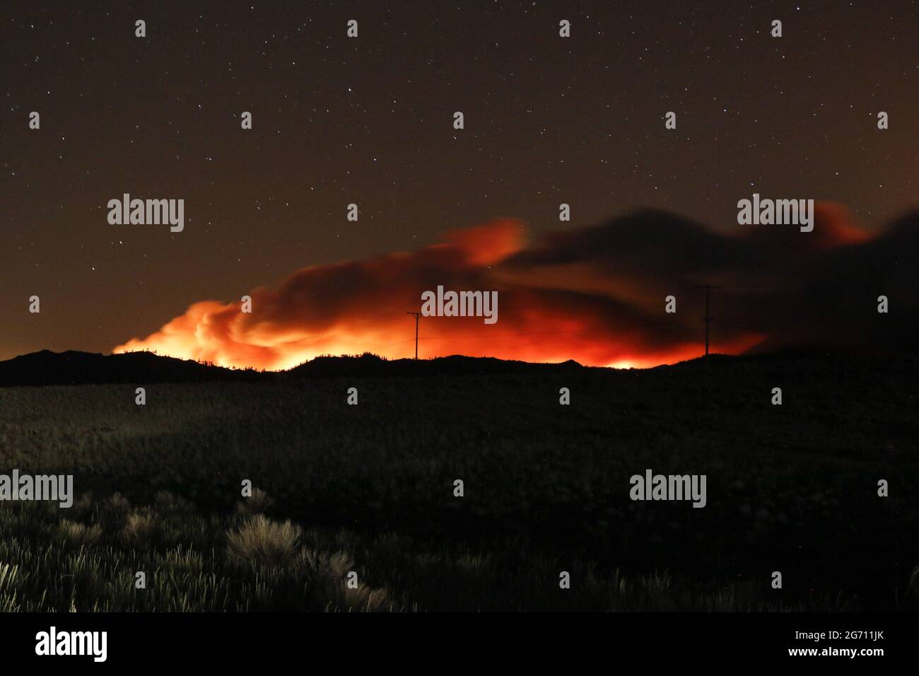 Flames illuminate the smoke rising from the Beckwourth complex fire