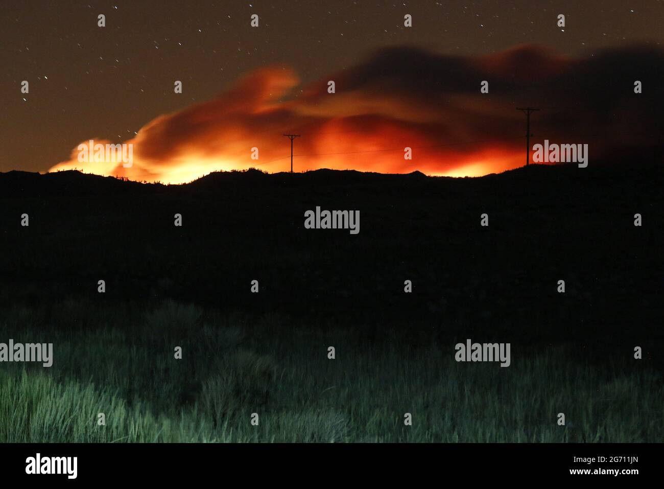 Flames illuminate the smoke rising from the Beckwourth complex fire