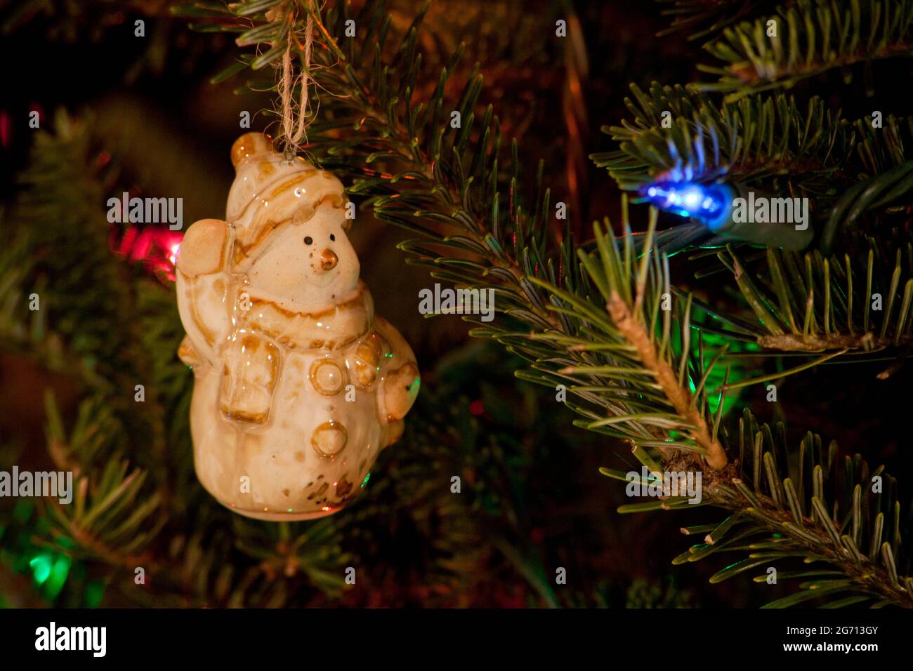 Snowman ornament hanging on Christmas Tree Stock Photo