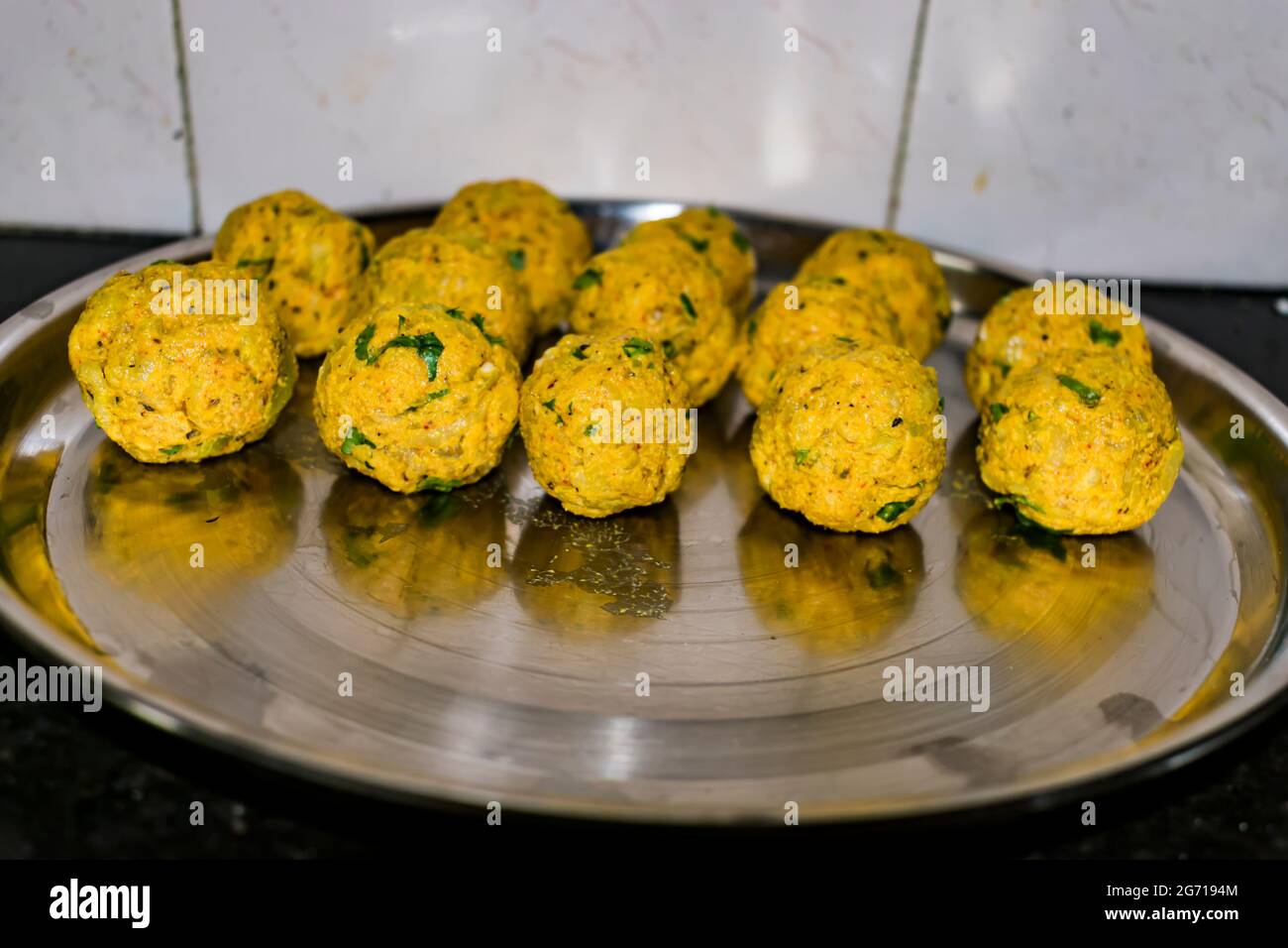 Vegetarian Kopta ready for frying kept on a plate after made in circular shape. Stock Photo