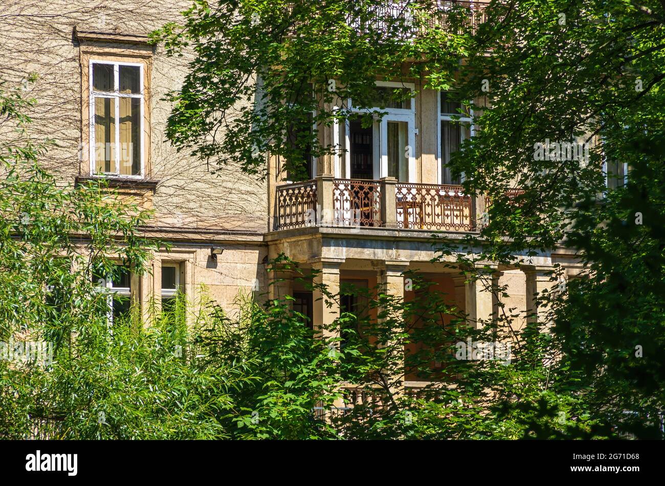 Tübingen, Baden-Württemberg, Germany: Rear side of a historic building half hidden by trees and bushes with balcony on Uhlandstrasse. Stock Photo
