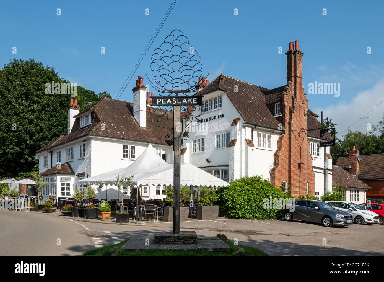 Peaslake, pretty village in the Surrey Hills AONB, England, UK. Village sign and the Hurtwood Inn. Stock Photo