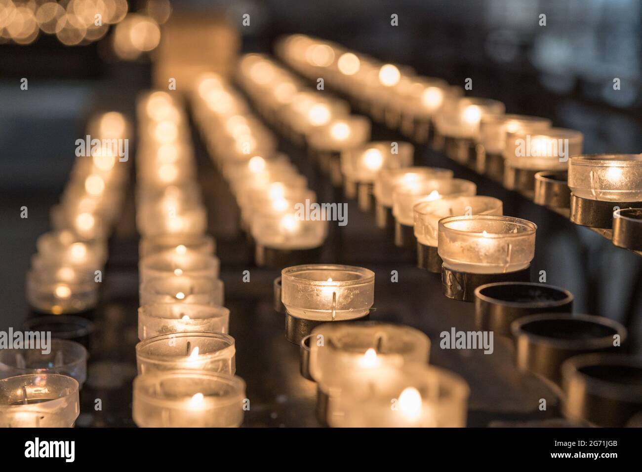 glowing candles for prayer in a church Stock Photo Alamy