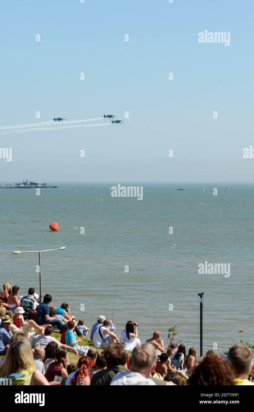 Southend Airshow 2012. Seafront crowds with displaying aircraft flying over the Thames Estuary. The Blades display team, watched by people on Cliffs Stock Photo