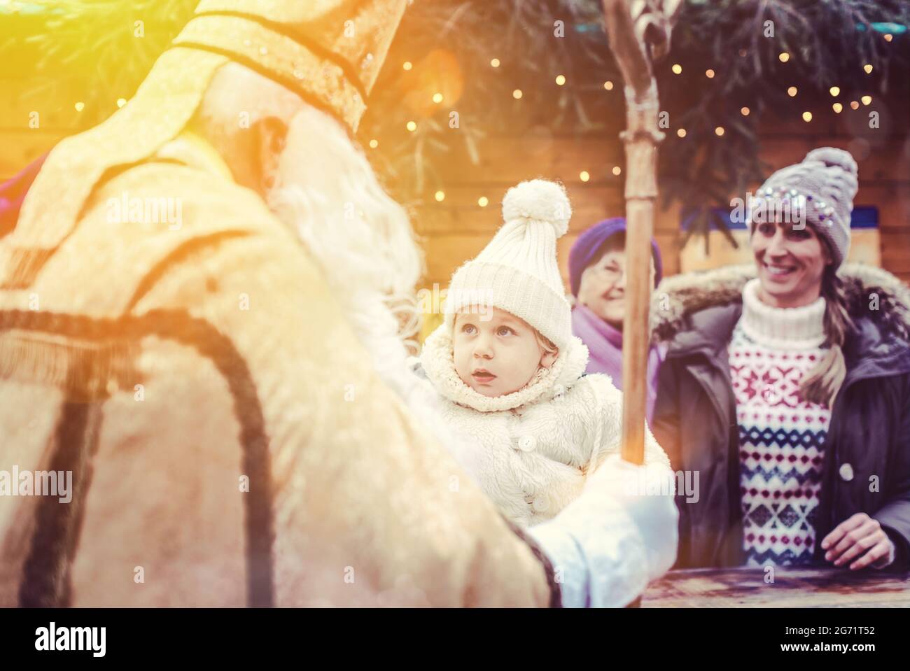 St Nicholas and an extended family with child on the Christmas market Stock Photo