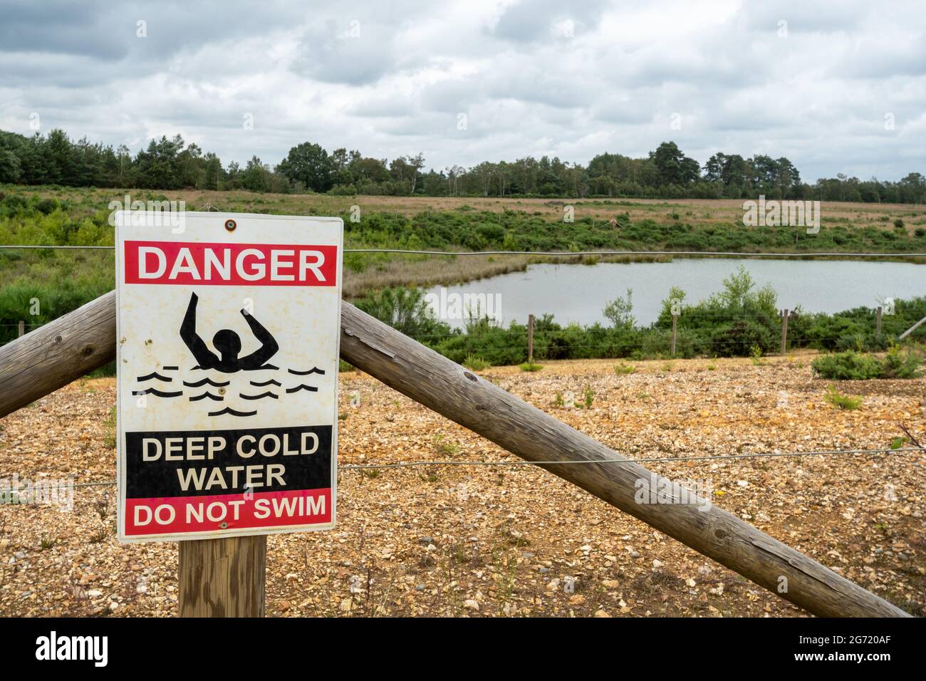 Danger, deep cold water, do not swim warning notice beside a quarry lake, UK Stock Photo