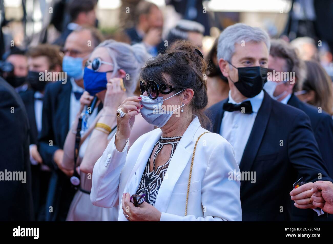 Cannes, France. 09th July, 2021. Palais des festivals, Cannes, France. 9th July, 2021. Festival attendees in masks attends the 'Benedetta' Red Carpet. All attendees to the festival are required to wear masks in the Palais des festivals including on the red carpet. They are removed for photographs to be taken. Picture by Credit: Julie Edwards/Alamy Live News Credit: Julie Edwards/Alamy Live News Stock Photo