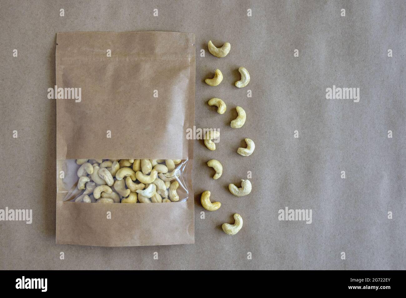 Cashew nuts in eco-friendly paper packaging and on craft paper. Healthy ...