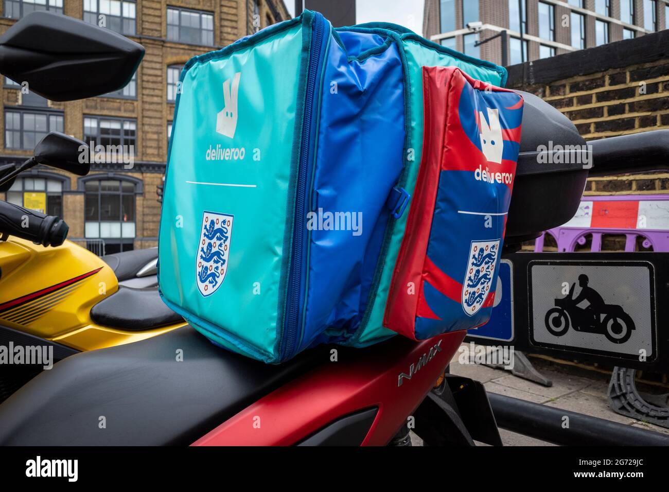 London, UK.  10 July 2021.  A Deliveroo delivery carrier on a motorcycle is decorated with the Three Lions in support of the England national football team. Italy play England tomorrow night in the final of Euro 2020 at Wembley Stadium.  It is the first major final that England will have played in since winning the World Cup in 1966 but Italy remain unbeaten in their last 33 matches.  Credit: Stephen Chung / Alamy Live News Stock Photo