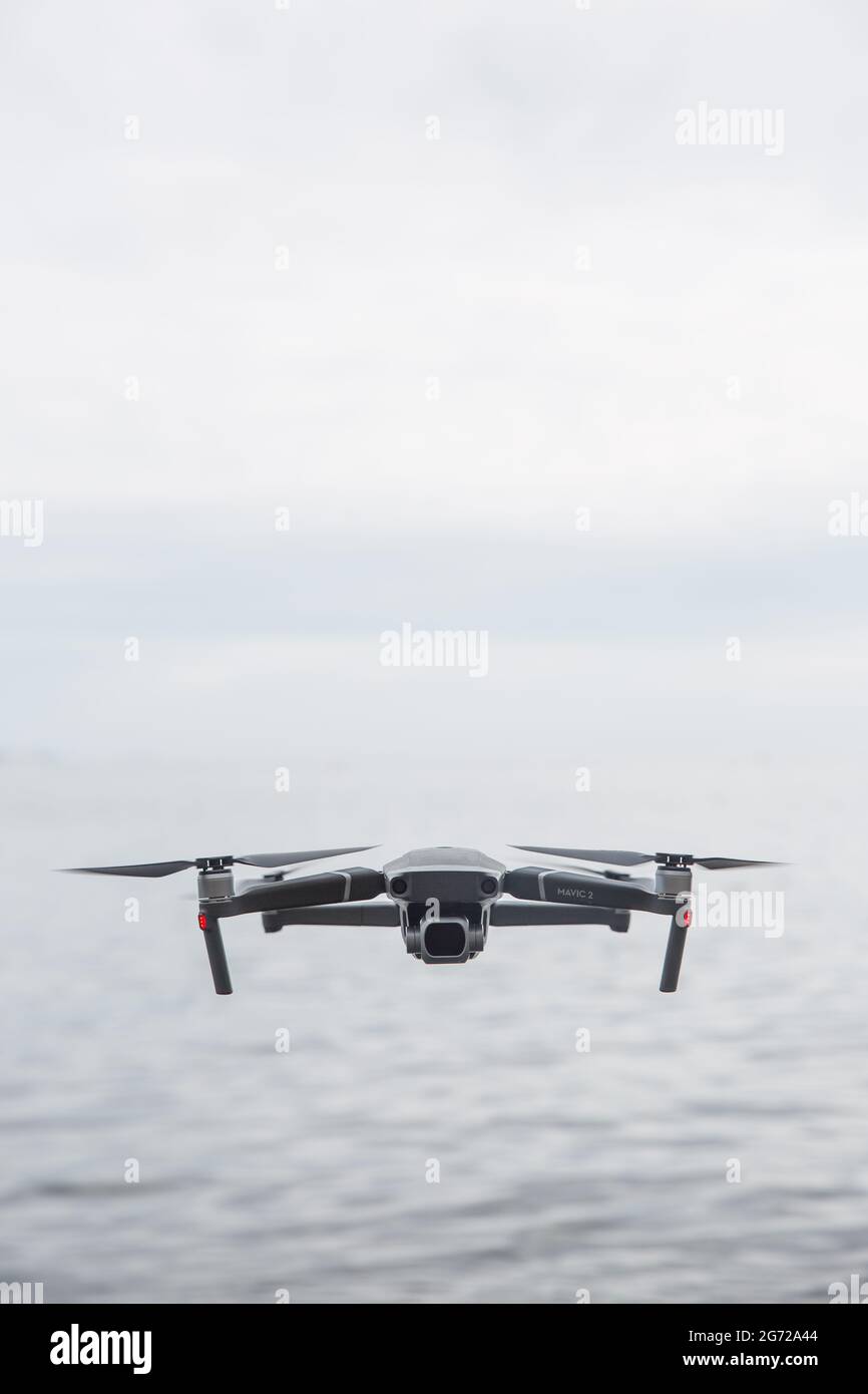 CORNWALL, UK - JUNE 29, 2021.  A DJI Mavic Pro 2 unmanned drone flying above water and facing the camera with copy space Stock Photo