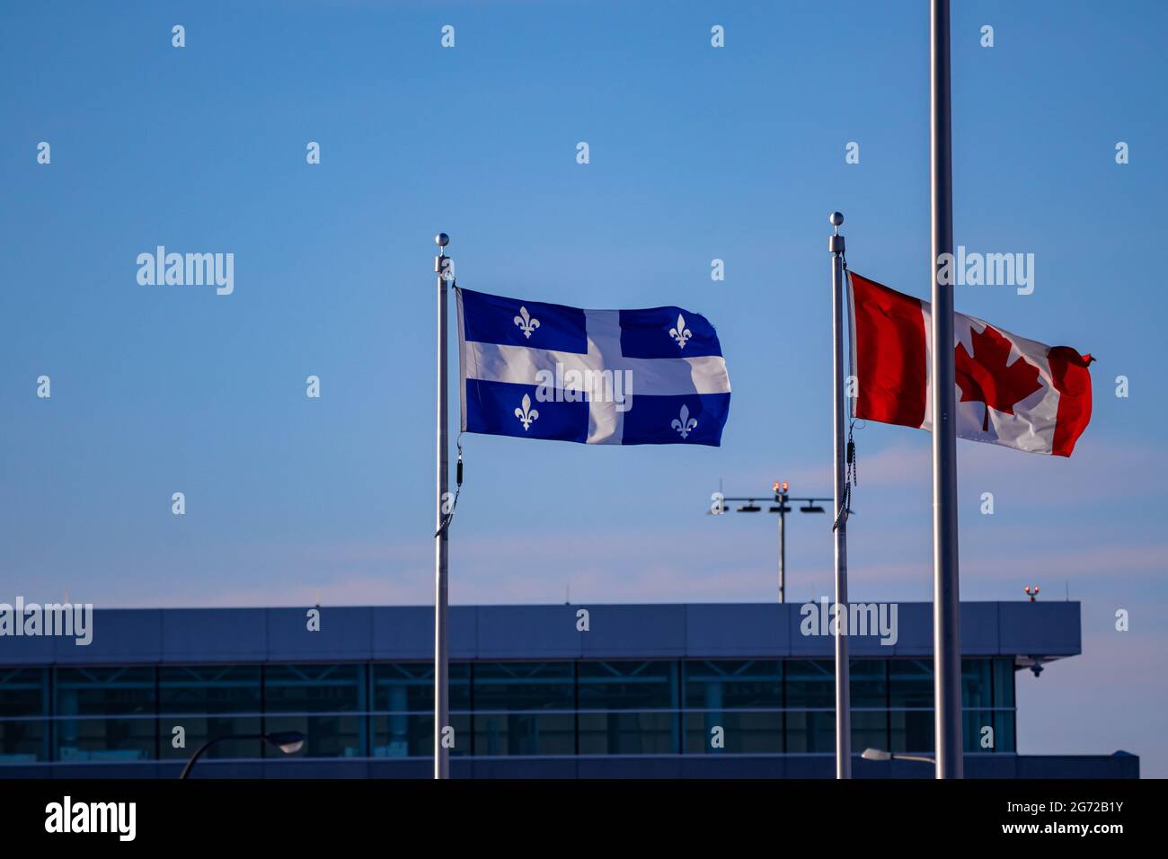 Quebec and Canadian flag fluttering in the wind at Quebec City's Airport. Stock Photo