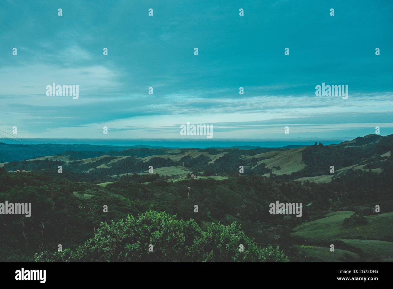 Landscape of hills covered in greenery under a blue cloudy sky Stock ...