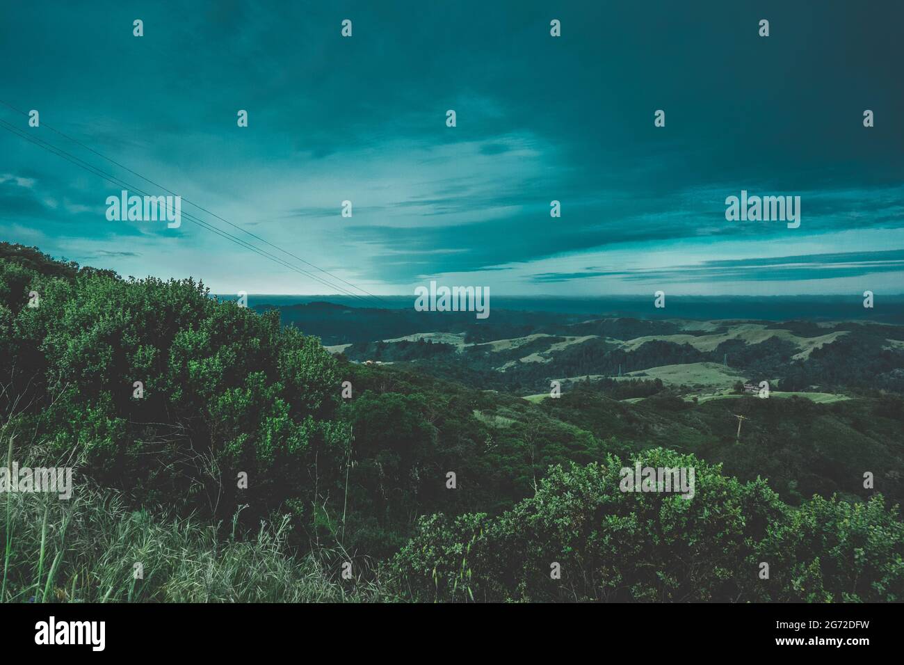 Landscape of hills covered in greenery under a blue cloudy sky Stock ...