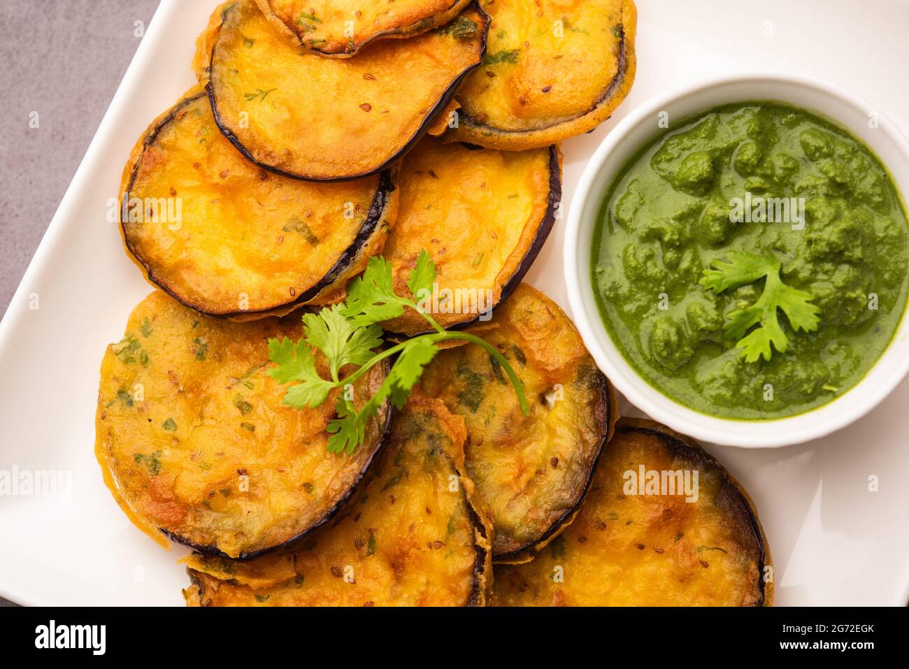 Tasty Brinjal Pakora or crispy eggplant fritters, Indian tea time snack served with green