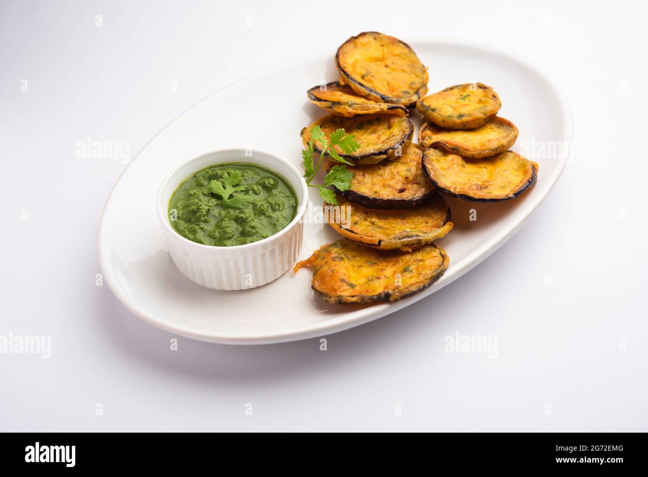 Tasty Brinjal Pakora or crispy eggplant fritters, Indian tea time snack served with green