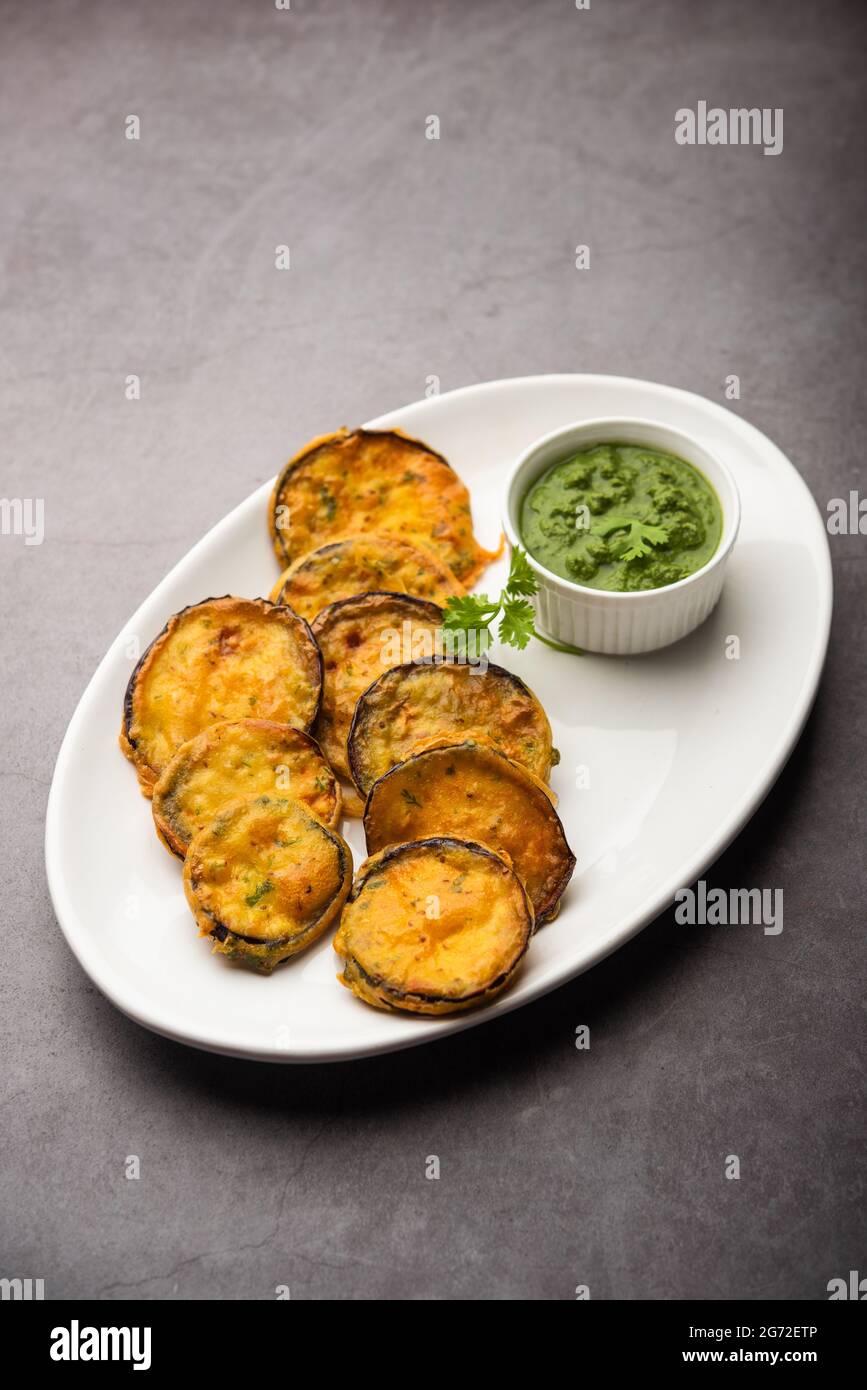 Tasty Brinjal Pakora or crispy eggplant fritters, Indian tea time snack served with green