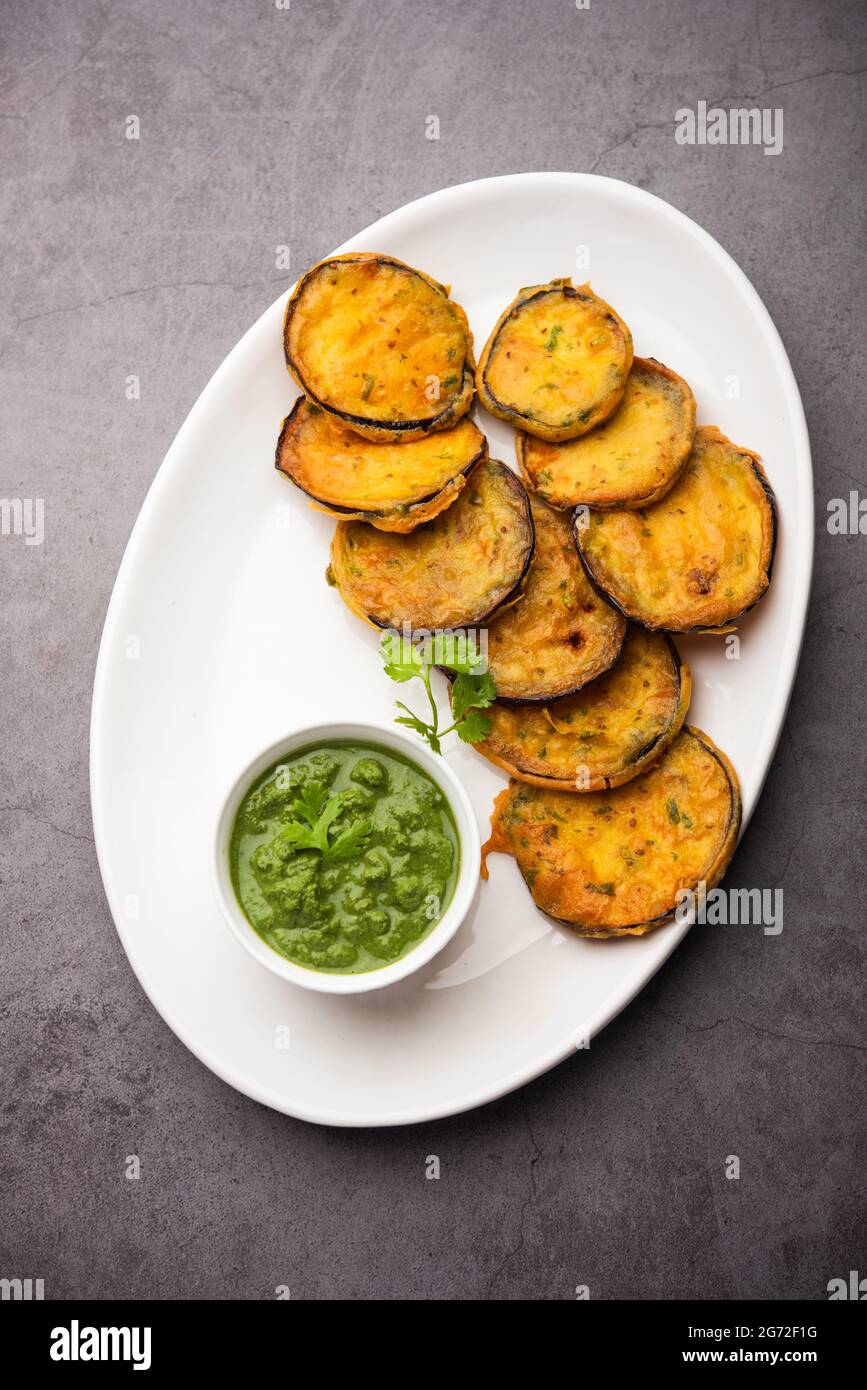 Tasty Brinjal Pakora or crispy eggplant fritters, Indian tea time snack served with green
