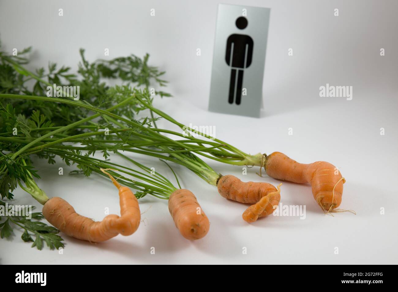 Isolated rude carrots with a 'male' sign on a white background Stock Photo