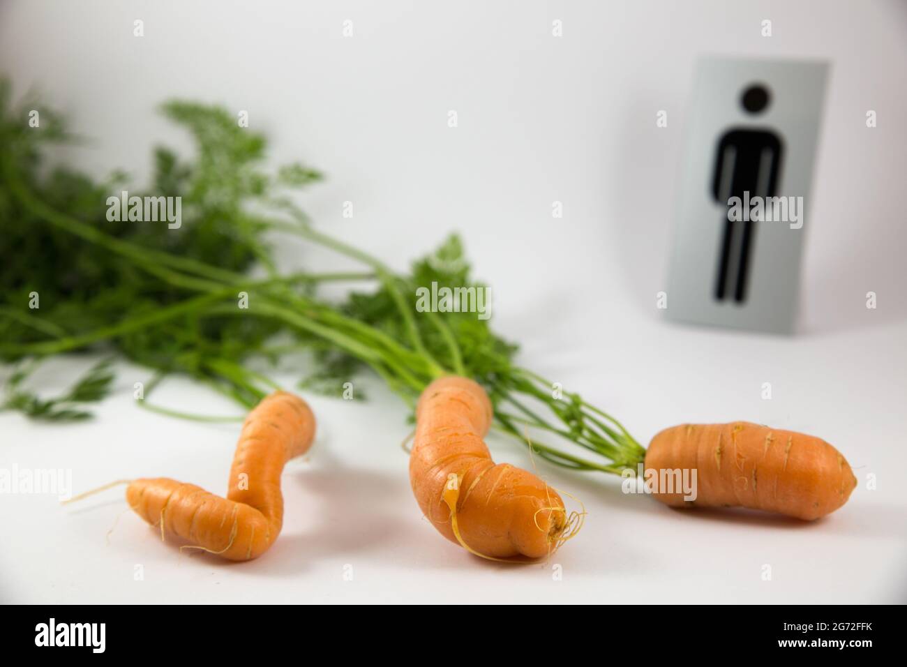 Isolated rude carrots with a 'male' sign on a white background Stock Photo
