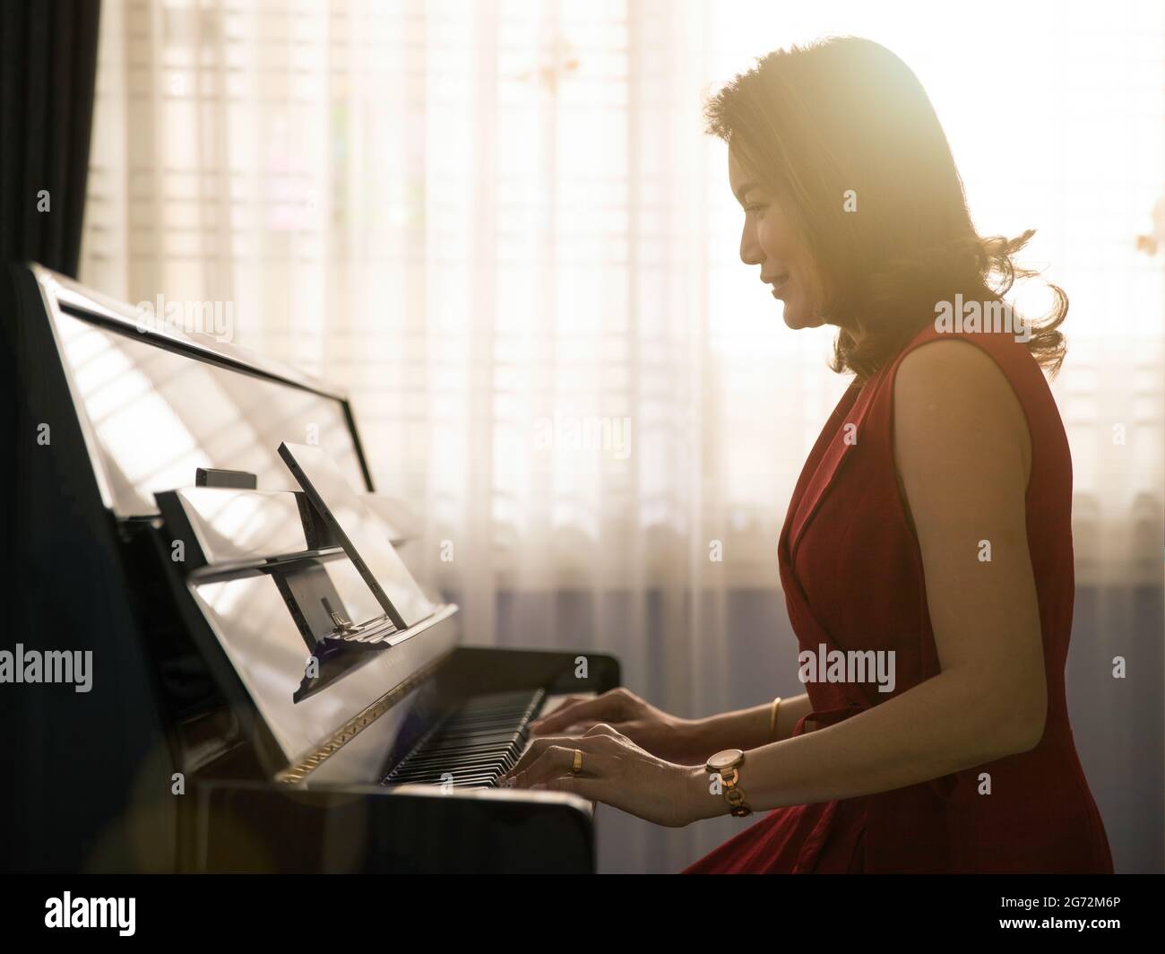 Middle age dignified Asian woman learning and studying new skills how ...