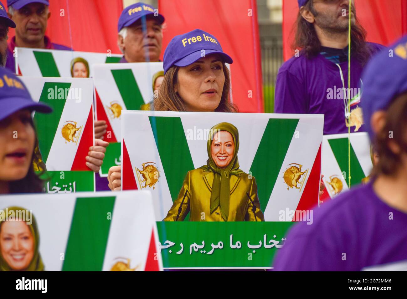 London, UK. 10th July, 2021. Protesters wearing Free Iran caps hold pictures of Maryam Rajavi during the Free Iran World Summit in London. Demonstrators gathered outside Downing Street to protest against the Iran regime and in support of Maryam Rajavi, the leader of the People's Mujahedin of Iran (MEK). Credit: SOPA Images Limited/Alamy Live News Stock Photo
