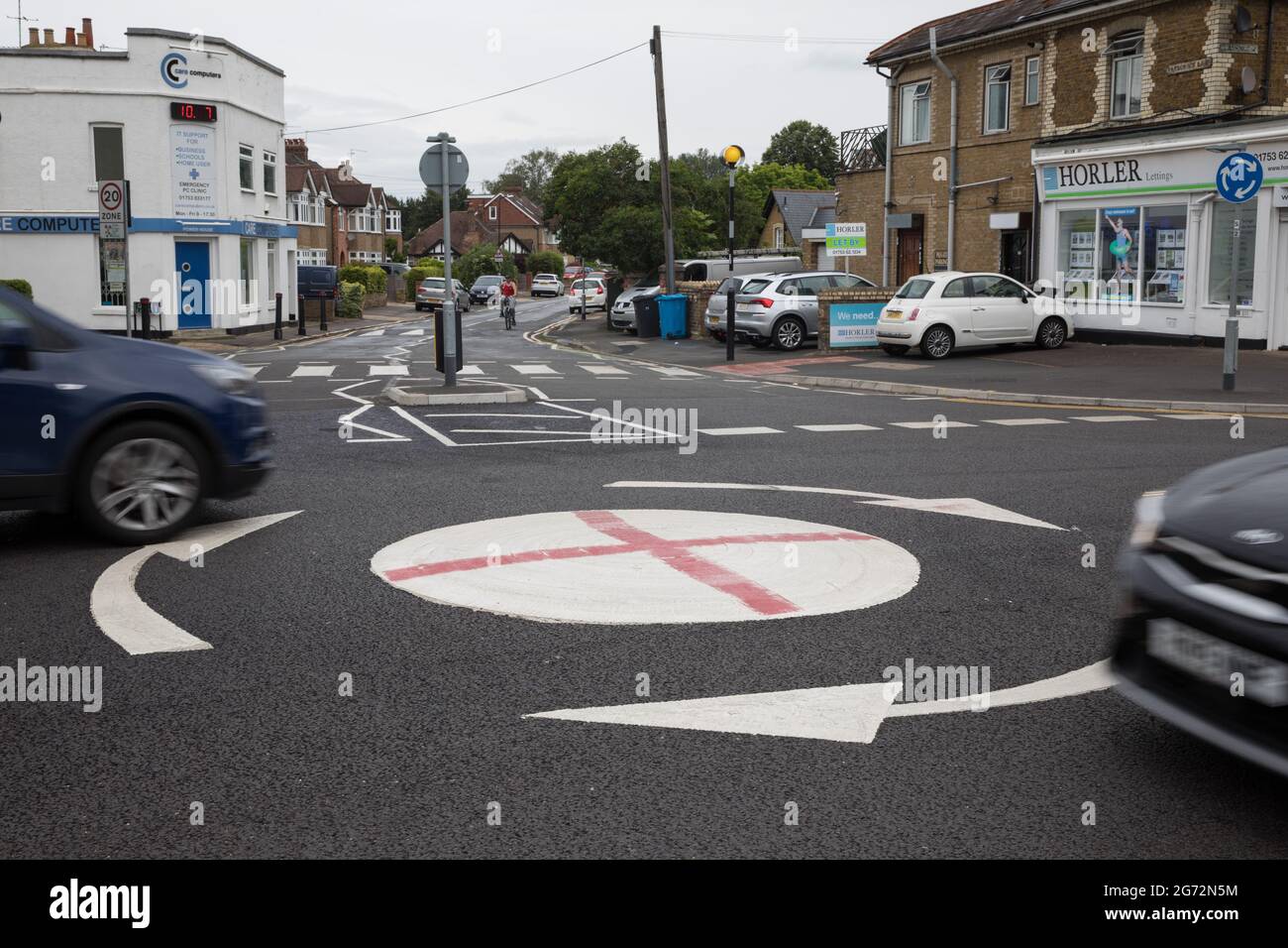 Windsor, UK. 10th July, 2021. Vehicles pass a mini-roundabout painted with the St George's flag. The Royal Borough of Windsor and Maidenhead repainted several roundabouts for safety reasons previously daubed with England flags before England's Euro 2020 quarter-final match against Ukraine but it appears that local residents have restored them in advance of the Euro 2020 final between England and Italy. Credit: Mark Kerrison/Alamy Live News Stock Photo