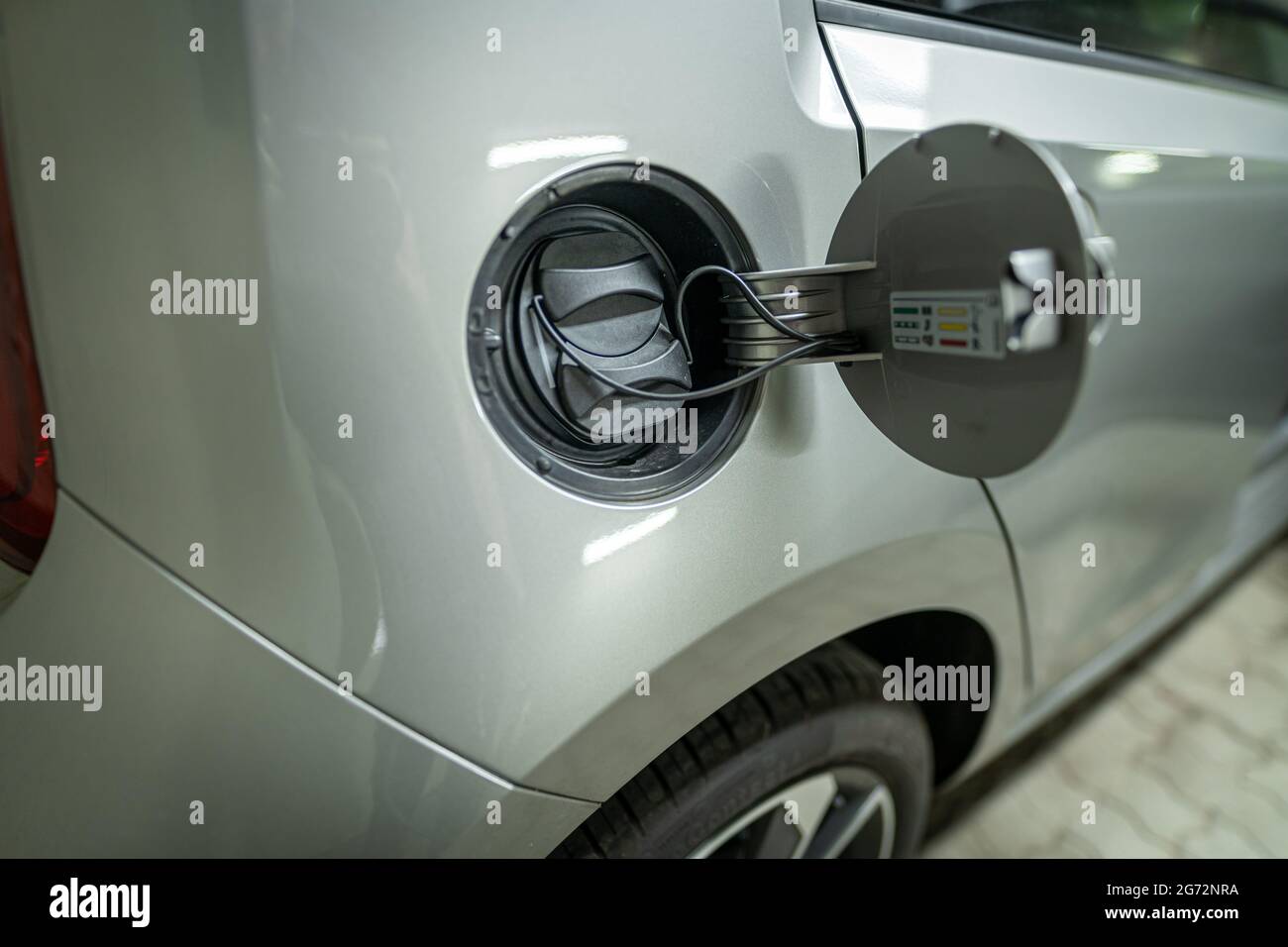 Open fuel cap of a electric car which is ready to get recharged with green power eco electricity. Stock Photo