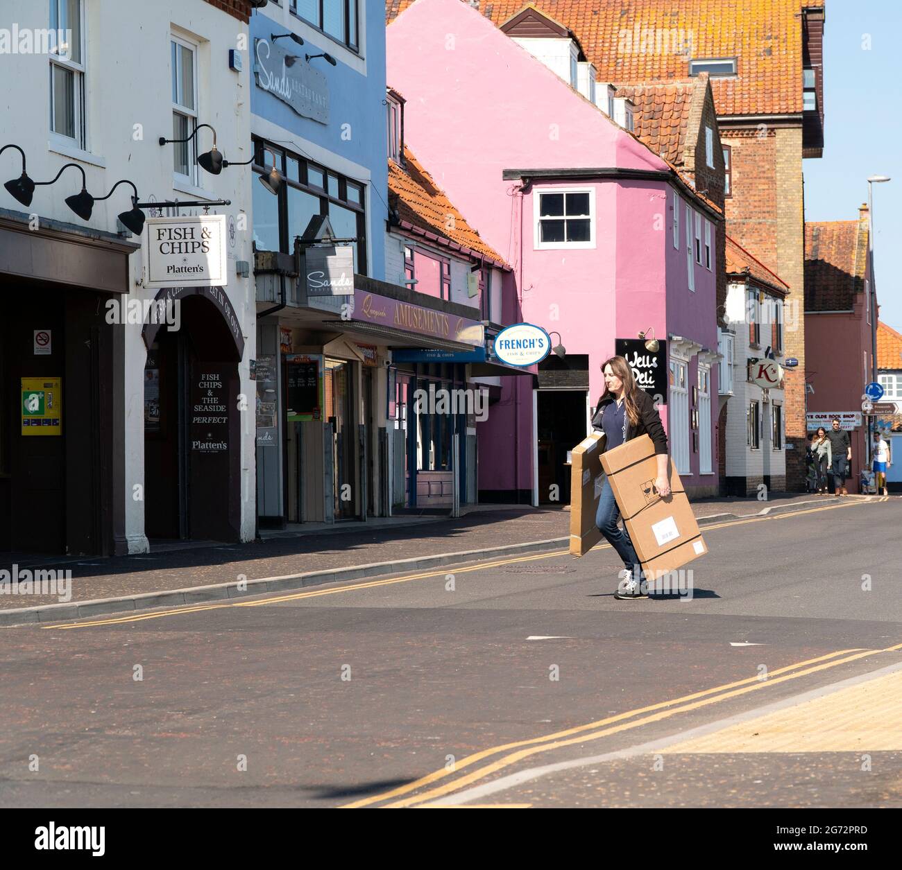 Woman carrying cardboard boxes across a road Stock Photo Alamy