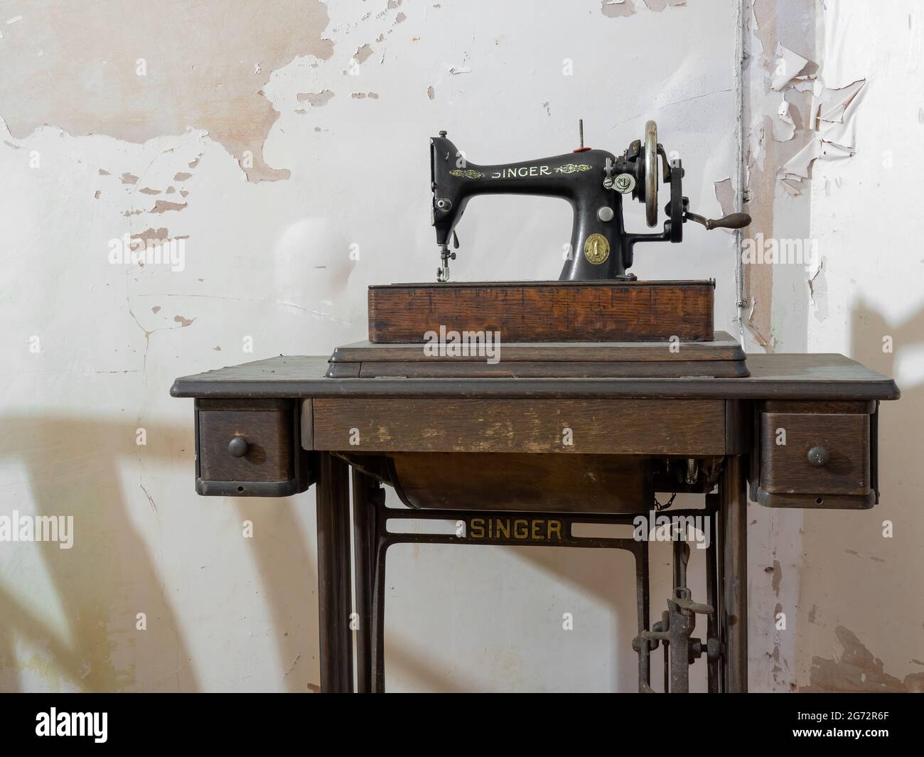 EXETER, UK - JUNE 29 2021: Old Singer treadle sewing machine in abandoned house. Stock Photo