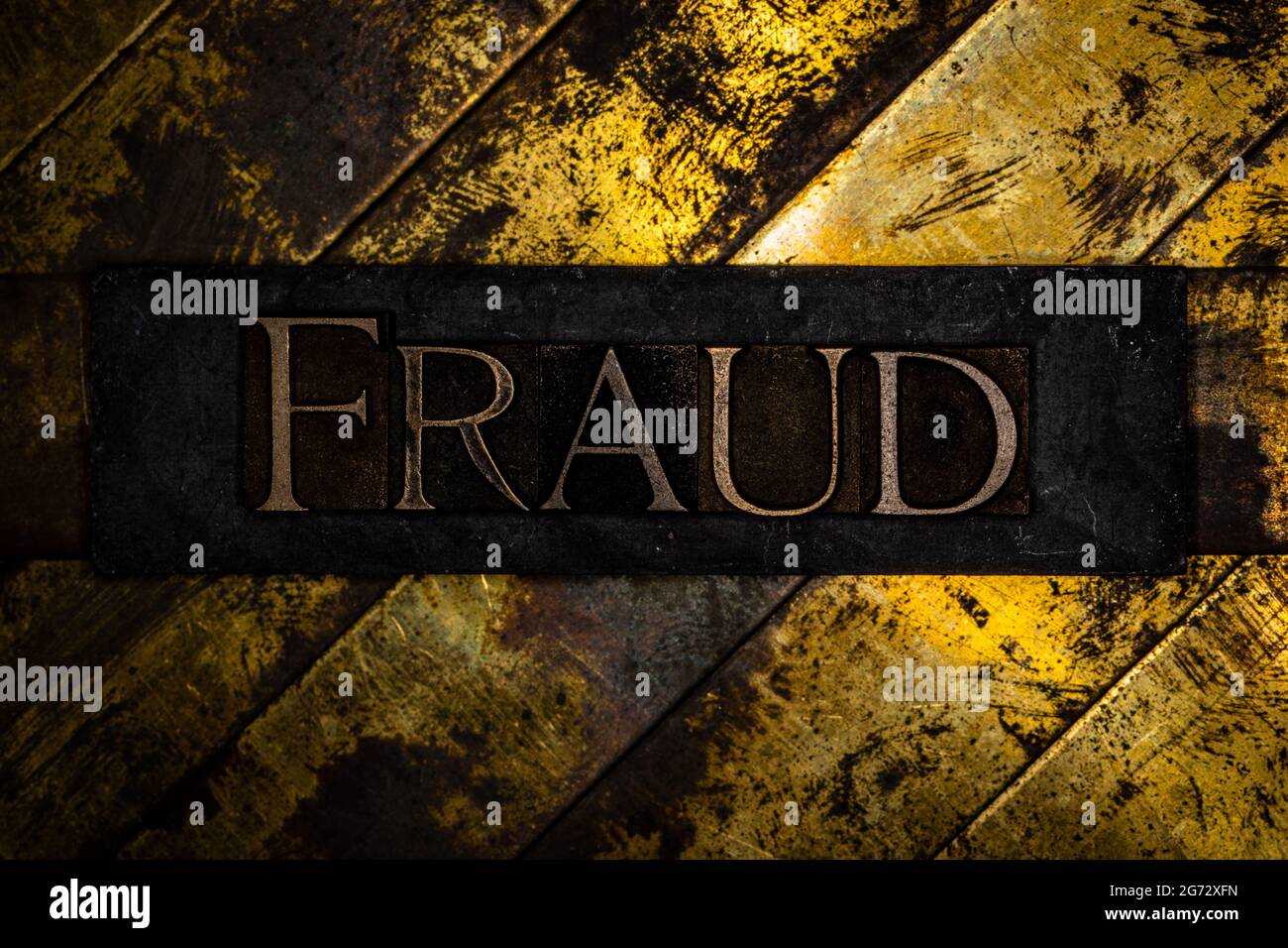 Fraud text on vintage textured grunge copper and gold background Stock Photo